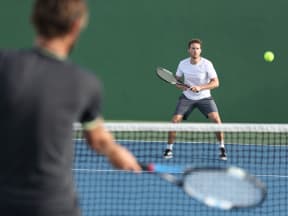 two young men playing tennis