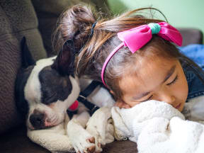 a child and a dog snuggling together