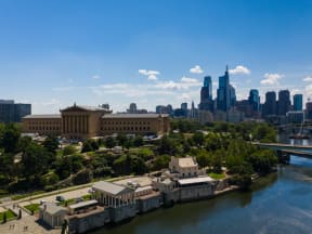 the Philadelphia Water Works and Philadelphia Museum of Art next to the river with the skyline behind it