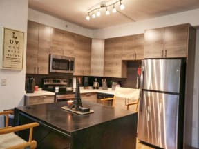Kitchen with appliances, cabinets, granite marble island at The Mobile Lofts, Mobile, Alabama
