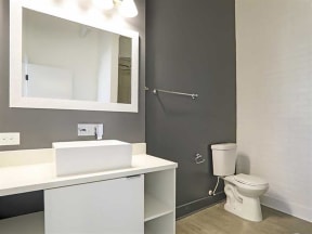 Bathroom with mirror, tub and cabinets at The Mobile Lofts, Mobile, AL, 36604