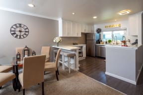 Walnut Hill Apartments in Walnut Creek, CA modern kitchen and dining area with white cabinetry and full size appliances