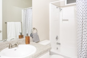Full size bathroom with vanity and shower and tub combo.