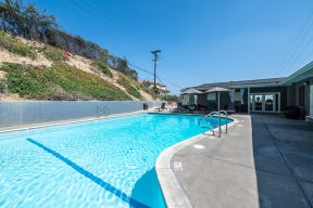 Pool with lounge chairs  l Emerald Hills Apartments in Monterey Park