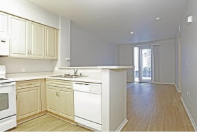 an empty kitchen and living room with a sliding glass door leading to a balcony at K Street Flats, Berkeley, CA