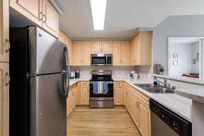 a kitchen with wooden cabinets and stainless steel appliances at K Street Flats, Berkeley, 94704