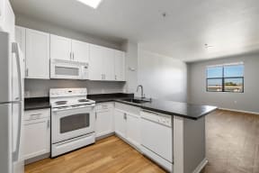 a kitchen with white cabinets and a black counter top at K Street Flats, Berkeley