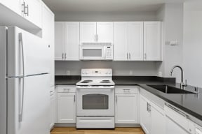 a kitchen with white cabinets and white appliances at K Street Flats, Berkeley, CA 