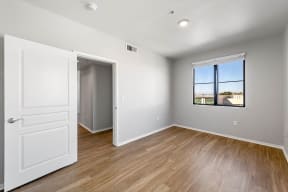 a bedroom with hardwood floors and a large window at K Street Flats, Berkeley, CA