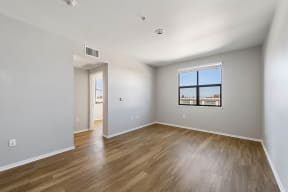 a bedroom with hardwood floors and a large window at K Street Flats, California, 94704
