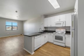 a kitchen with white cabinets and a black counter top at K Street Flats, Berkeley California