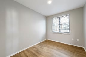 a bedroom with hardwood floors and a window at K Street Flats, Berkeley California