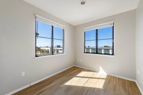 a bedroom with two windows and hardwood floors at K Street Flats, California, 94704