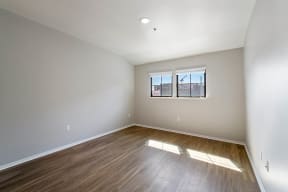 a bedroom with hardwood flooring and two windows at K Street Flats, Berkeley, 94704