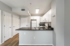 a kitchen with white cabinets and a black counter top at K Street Flats, Berkeley, 94704