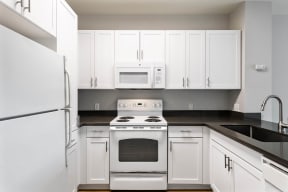 a kitchen with white cabinets and white appliances at K Street Flats, California, 94704