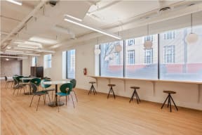 a large room with wooden floors and a long counter with stools and tables at K Street Flats, California, 94704