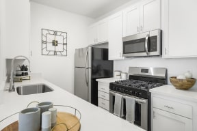 Kitchen with stainless steel appliances l The Enclave in Paramount CA