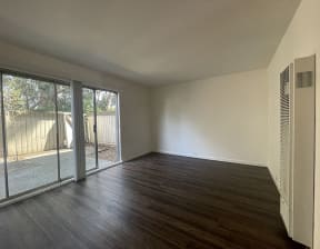 North Oakland CA Apartments - Spacious Living Room with Hardwood Floors Also Featuring Sliding Door that Leads to Private Patio