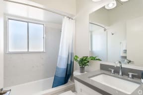 Mountain View Apartments for Rent - Glenwood Garden - Modern Bathroom With Vanity Mirror, Toilet, and a Shower With a Clouded Window