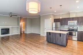 Apartments for Rent in Happy Valley - Latitude Kitchen with Wood-Style Cabinetry, Laminate Flooring, Stainless-Steel Appliances, Large Window, and White Countertops