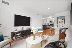 a living area with a couch coffee table and a television on the wall