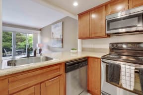 Los Gatos CA Apartments for Rent - El Gato Penthouse - Kitchen with Wood-Style Cabinets, Stainless Steel Appliances, and Beige Granite Countertops