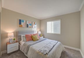 Sienna Pointe Pet-Friendly Apartments in Moreno Valley, CA - Bedroom With Wall to Wall Carpet, Stylish Decor, White Walls, and a Large Window