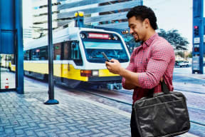 Man on cell phone near public transportation train