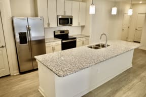 Ladson SC Apartments for Rent - Expansive Kitchen Fully Equipped with Modern Amenities Such as Fridge, Microwave, and Stove Also Featuring a Kitchen Island