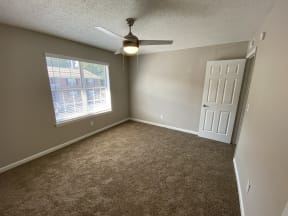Apartments for Rent in North Charleston SC - The Retreat at Palm Pointe Apartments Spacious Bedroom With Window, Cozy Carpeting, And Ceiling Fan
