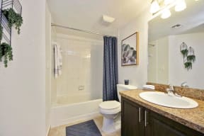 Bathroom with sink, cabinets, toilet, mirror, and tub shower