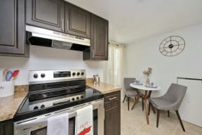 Eat-in kitchen with small table with two chairs and stainless steel oven