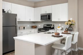 803 Corday at Naperville - Modern Kitchen with White Countertops, Sleek Cabinets, and Stainless Steel Appliances