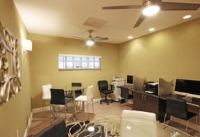 Business center with 2 computers and two tables with chairs