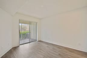 Bedroom with vinyl flooring and balcony door