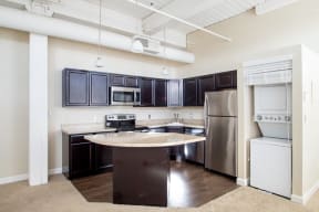 Dark kitchen cabinets with extra storage and breakfast bar or kitchen island at The Greenhouse Apartments in Omaha, NE