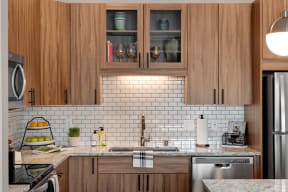 Wood cabinets and tile backsplash in Kitchen at Modern kitchen at Nuvelo at Parkside Apartments