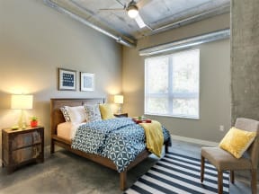 Be @ Axon Green Apartment Bedroom with Large Window and Concrete Floor
