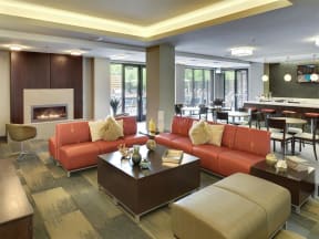 Be @ Axon Green Community Room with comfy chairs, couches, coffee table, and fire pit