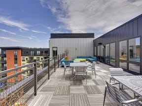 Be @ Axon Green Rooftop Patio with tables, chairs, and couches