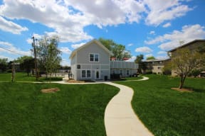 View of clubhouse exterior with lush green grass and blue sky