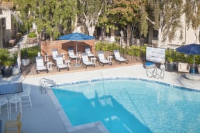 Apartments in Thousand Oaks CA - The Knolls - Pool Area with Lounge Chairs and Umbrellas