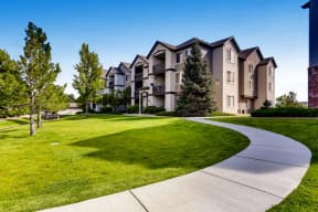 Apartments for Rent Denver CO - Allure - Exterior Apartment Building with Beige Siding and Lush Landscaping