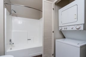 bathroom with front load stacked washer and dryer