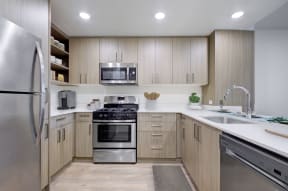 Apartments for Rent San Mateo - Mode Apartments - Kitchen with Woodstyle Cabinetry, Sleek Countertops, and Stainless Steel Appliances