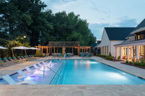 Swimming pool in the evening with purple underlighting and outdoor patio