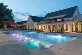 Beautiful swimming pool lounge area at dusk with soft ambient lighting.