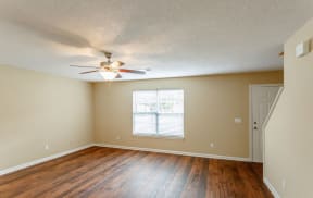 Dana Downs Open Space Living Room Featuring Hardwood Floors, Ceiling Fan, and Staircase Leading to Second Floor