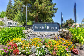 Rush River Monument Sign with Flower Bed, Trees and Plants
